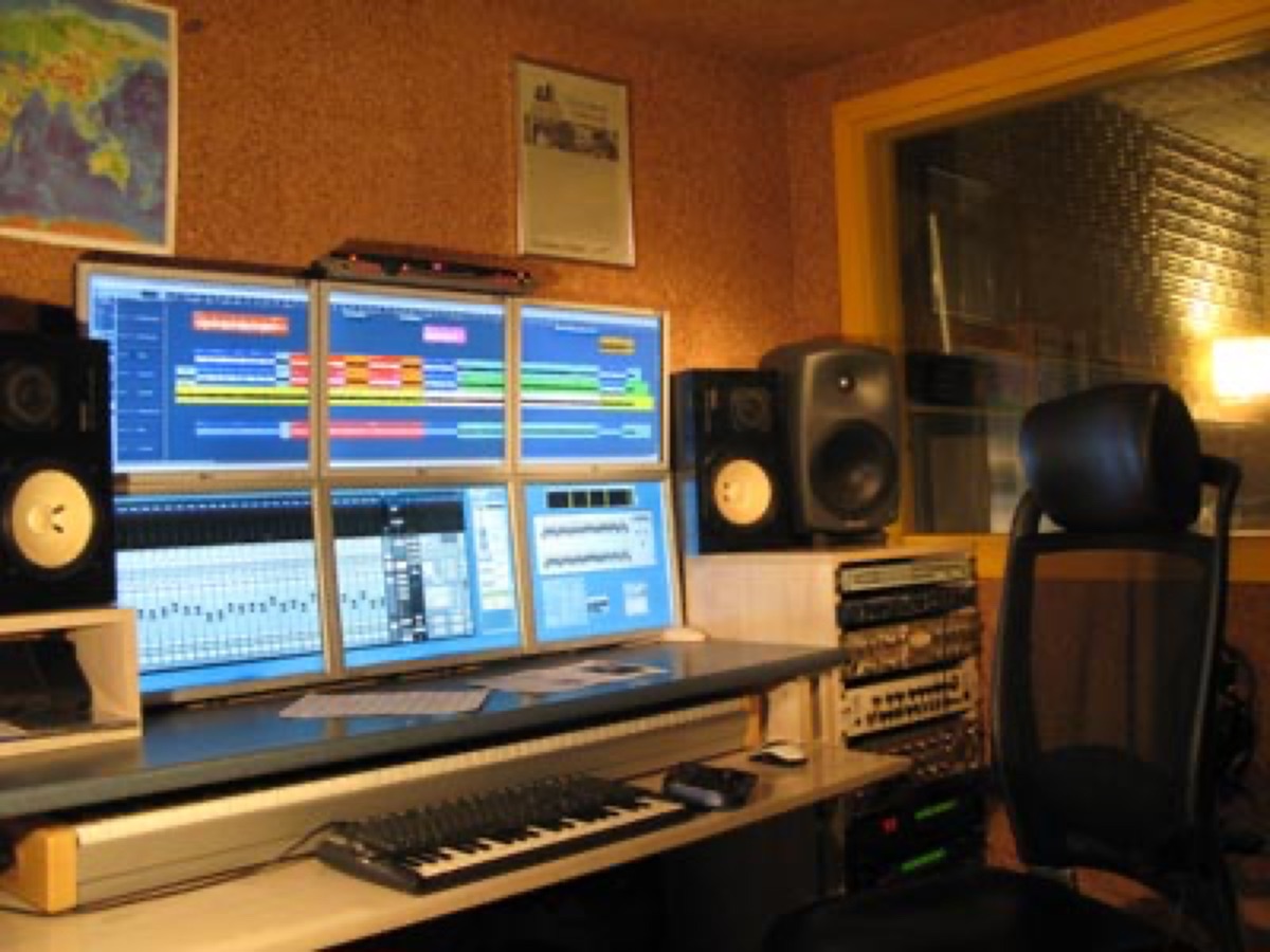 A modern music producer's workspace with digital audio workstation software on screen