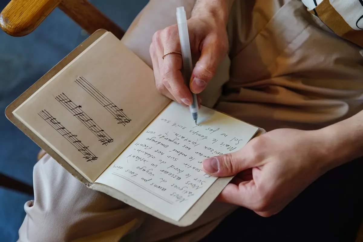 男性作詞家がノートに歌词と音符を書く