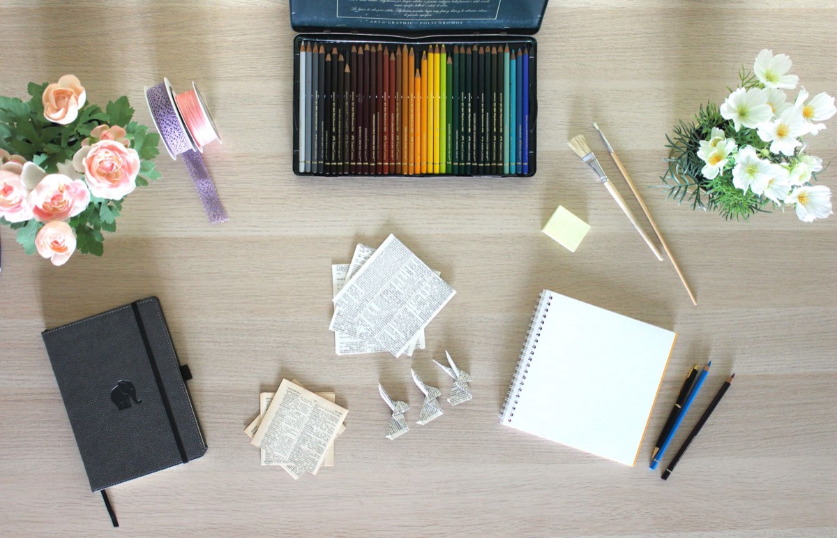 K-artist con notebook e taccuino, luce soffusa, toni pastelli